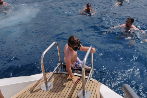 Child entering the ocean from a Catamaran in Tenerife