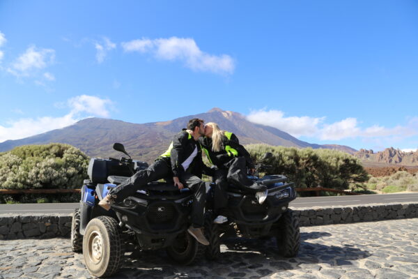 Couple kissing on Mount Teide while sitting on quads